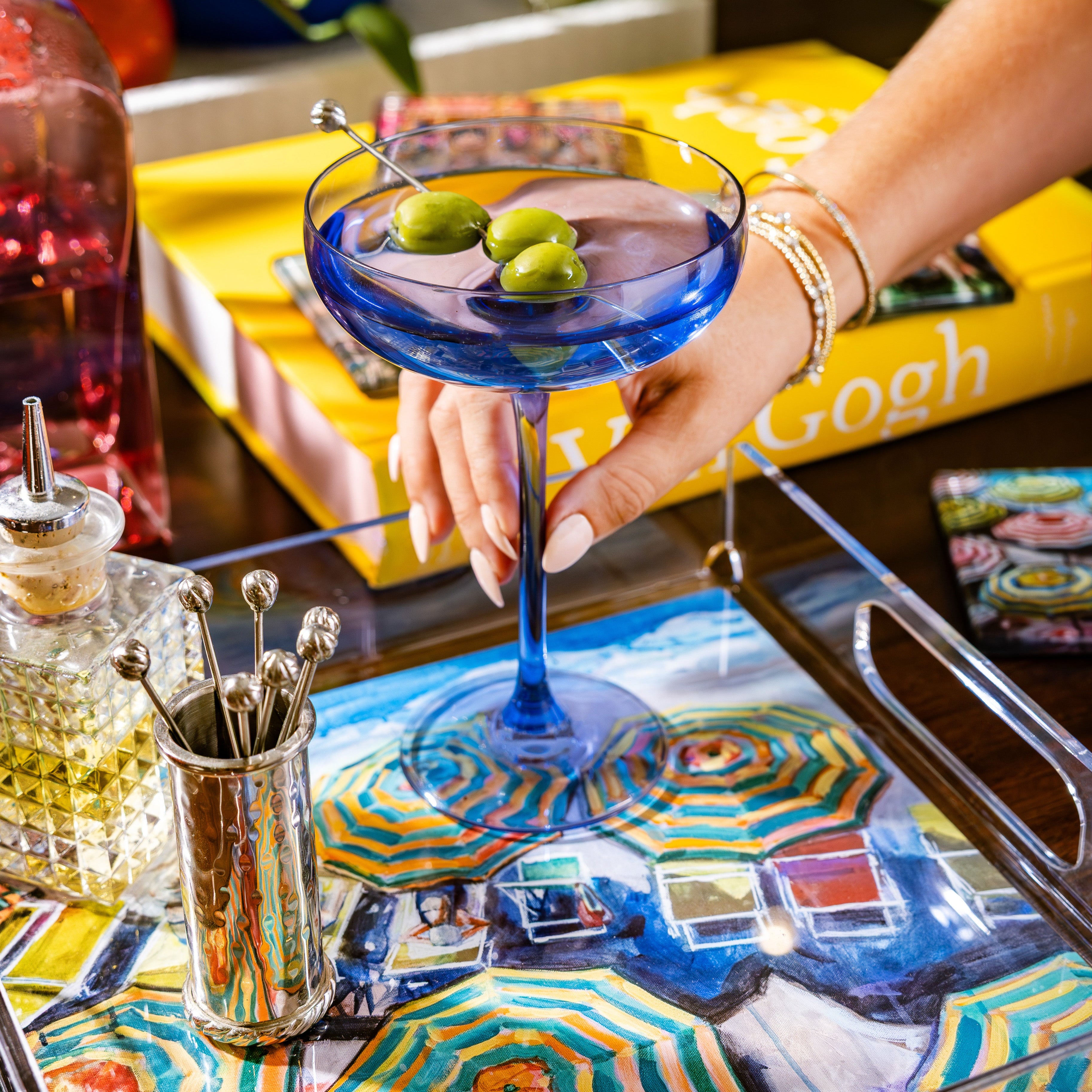 Amalfi Coast décor collection – acrylic tray painted by artist Laura Duke. Elegant coastal accents & Mediterranean-inspired home gifts. Girl holding martini glass on Amalfi acrylic tray painted by artist Laura Duke. 